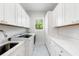 Clean laundry room with white cabinets and herringbone floor at 931 Bayshore Rd, Nokomis, FL 34275