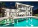 Expansive pool with patio and outdoor kitchen at night at 931 Bayshore Rd, Nokomis, FL 34275