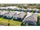 Aerial view featuring stylish homes with well-kept lawns in a community near a scenic pond at 11380 Burgundy Dr, Venice, FL 34293