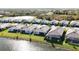 Overhead view of modern homes bordering a picturesque pond, showcasing community and natural beauty at 11380 Burgundy Dr, Venice, FL 34293