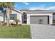 Beautiful one-story home with a two-car garage, brick paver driveway and manicured lawn at 11380 Burgundy Dr, Venice, FL 34293