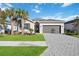 Beautiful one-story home with a two-car garage, brick paver driveway and manicured lawn at 11380 Burgundy Dr, Venice, FL 34293