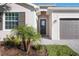 Close-up of the front entrance showcasing a glass door, brick pavers and manicured landscaping at 11380 Burgundy Dr, Venice, FL 34293