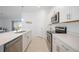 Bright kitchen featuring white cabinets, stainless steel appliances, and a large island with a sink at 11380 Burgundy Dr, Venice, FL 34293