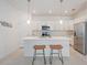 Modern kitchen boasts a large island with pendant lighting, stainless steel appliances, and ample cabinet space at 11380 Burgundy Dr, Venice, FL 34293