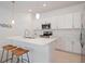 Modern kitchen features white cabinets, stainless steel appliances, and a large island with seating at 11380 Burgundy Dr, Venice, FL 34293