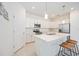 Bright and open kitchen features a center island with bar seating, ample cabinetry, and modern appliances at 11380 Burgundy Dr, Venice, FL 34293