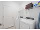 Laundry room with white washer and dryer, shelving and a door at 11380 Burgundy Dr, Venice, FL 34293