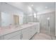 Elegant main bathroom features a double vanity with quartz countertops and a glass-enclosed shower at 11380 Burgundy Dr, Venice, FL 34293