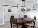 Charming dining room with farmhouse-style table, pendant lighting, and sliding barn door at 120 Lookout Point Dr, Osprey, FL 34229