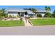 Gray house with metal roof, landscaping, and paved pathway at 120 Lookout Point Dr, Osprey, FL 34229