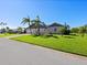 Gray house with metal roof, landscaping, and two palm trees at 120 Lookout Point Dr, Osprey, FL 34229