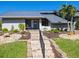 Gray house with metal roof, landscaping, and a walkway at 120 Lookout Point Dr, Osprey, FL 34229