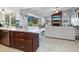 Eat-in kitchen with island and view into living room with fireplace and pool access at 120 Lookout Point Dr, Osprey, FL 34229