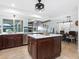 Open kitchen with island, stainless steel appliances, and view into adjacent living area at 120 Lookout Point Dr, Osprey, FL 34229