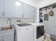 Bright laundry room with washer, dryer, and ample cabinets at 120 Lookout Point Dr, Osprey, FL 34229