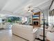 Bright living room with vaulted ceilings, a fireplace, and access to the outdoor patio and pool at 120 Lookout Point Dr, Osprey, FL 34229