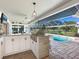 Outdoor kitchen with built-in grill, granite countertops, and white cabinets at 120 Lookout Point Dr, Osprey, FL 34229