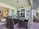 Outdoor patio with glass-top dining table, wicker chairs, and partial view of the home's interior at 120 Lookout Point Dr, Osprey, FL 34229