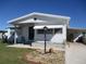 White single-wide manufactured home with carport and landscaped front yard at 1208 44Th Avenue E Dr, Ellenton, FL 34222