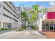 Exterior view of Bay Plaza entrance with lush landscaping, palm trees and parking garage access at 1255 N Gulfstream Ave # 1101, Sarasota, FL 34236