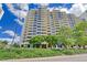 The exterior of a modern condominium building under a bright sky, surrounded by lush greenery and well-maintained landscaping at 1255 N Gulfstream Ave # 1101, Sarasota, FL 34236