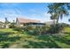 Landscaped backyard featuring lush greenery, complemented by a screened porch for outdoor enjoyment at 148 Inlets Blvd # 148, Nokomis, FL 34275