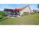 Relaxing patio with seating area, red umbrella, and lush landscaping at 148 Inlets Blvd # 148, Nokomis, FL 34275