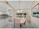 Charming dining area with chandelier, mirror, and direct access to the kitchen and enclosed lanai at 148 Inlets Blvd # 148, Nokomis, FL 34275