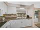 Bright kitchen featuring granite countertops, modern appliances, and an opening to the enclosed lanai at 148 Inlets Blvd # 148, Nokomis, FL 34275