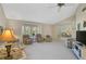 Bright living room with neutral carpet, comfortable seating, and natural light from a large window at 148 Inlets Blvd # 148, Nokomis, FL 34275