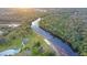 Aerial view of a waterfront property with lush greenery and a community building at 14924 Sora Way, Bradenton, FL 34212