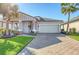 Gray Craftsman style home with a brick paver driveway and lush landscaping at 14924 Sora Way, Bradenton, FL 34212