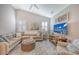 Spacious living room with sectional sofa, ottoman, and large TV at 14924 Sora Way, Bradenton, FL 34212