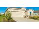 House exterior featuring beige siding, a two-car garage, and landscaping at 15813 6Th E Ave, Bradenton, FL 34212