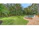 A lush backyard features a pool, lounge chairs, and mature trees, perfect for relaxation and outdoor enjoyment at 1682 Hawthorne St, Sarasota, FL 34239