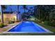 Evening view of the pool and backyard, with ambient lighting creating a tranquil and inviting outdoor space at 1682 Hawthorne St, Sarasota, FL 34239