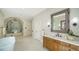 Bright bathroom with soaking tub, walk-in shower with tilework, and wooden vanity at 1682 Hawthorne St, Sarasota, FL 34239