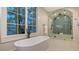 Bright bathroom featuring a soaking tub and glass-enclosed shower with detailed tilework at 1682 Hawthorne St, Sarasota, FL 34239