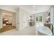 Bright bathroom with soaking tub, wooden vanity, and access to the backyard garden through french doors at 1682 Hawthorne St, Sarasota, FL 34239