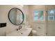Modern bathroom with a round mirror, vanity, and glass-enclosed shower at 1682 Hawthorne St, Sarasota, FL 34239