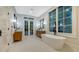 Bright bathroom featuring a soaking tub, wooden vanities, and window views overlooking lush greenery at 1682 Hawthorne St, Sarasota, FL 34239