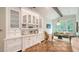 This kitchen features white cabinetry, a wet bar, and hardwood floors at 1682 Hawthorne St, Sarasota, FL 34239