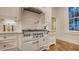A kitchen features white cabinetry, a large range with vent hood, and tile backsplash at 1682 Hawthorne St, Sarasota, FL 34239