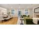 An open living space with hardwood floors, a dining table, and green sofas under recessed lighting at 1682 Hawthorne St, Sarasota, FL 34239
