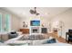 A living room with fireplace, television, stylish décor, large sofa and an open view into the dining room at 1682 Hawthorne St, Sarasota, FL 34239