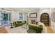 A cozy living room featuring hardwood floors, a fireplace, bookshelves, and plush green sofas at 1682 Hawthorne St, Sarasota, FL 34239