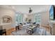 Bright living room with large sofa, big windows, stylish decor and beautiful wood floors at 1682 Hawthorne St, Sarasota, FL 34239