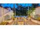 Inviting outdoor patio with dining and living spaces, featuring a fire pit, lush plants, and decorative fountains at 1682 Hawthorne St, Sarasota, FL 34239