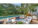 Inviting outdoor living space with a sparkling pool, comfortable lounge seating, and a cozy fire pit for relaxation and entertainment at 1682 Hawthorne St, Sarasota, FL 34239